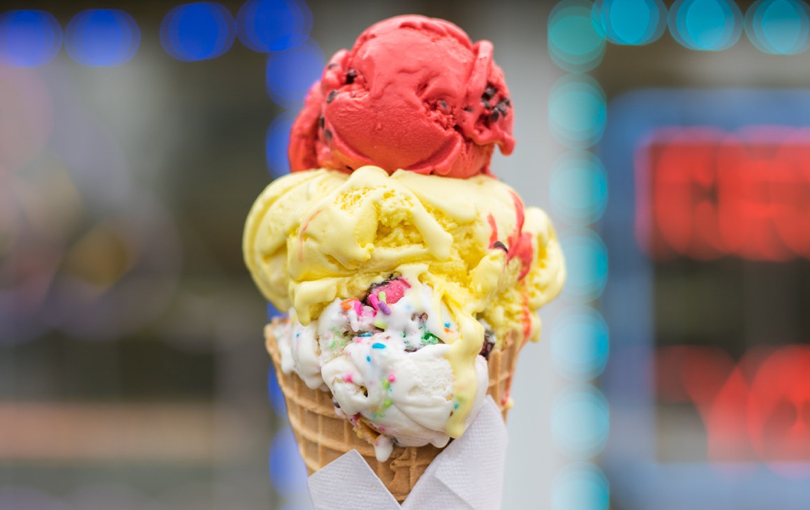 three scoops of ice cream stacked on a waffle cone